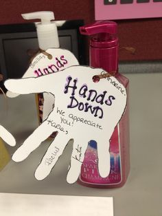 a pink hand sanitizer next to a sign that says hands down