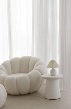 a living room with white furniture and curtains