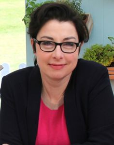 a woman wearing glasses sitting at a table