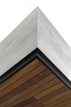 the corner of a building with wood and white paint on it's side wall