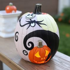 a decorated pumpkin sitting on top of a wooden table