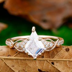 an engagement ring with a pear shaped diamond surrounded by smaller diamonds