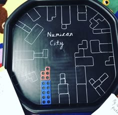 a close up of a black tray with writing on it and legos in the background