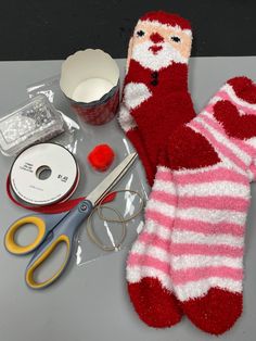 a pair of red socks sitting on top of a table next to scissors and other items