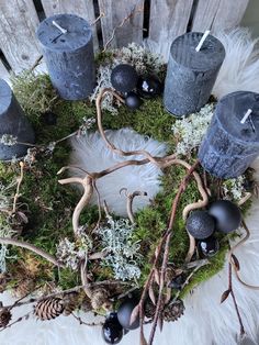 a wreath made out of candles and moss