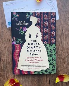 the dress diary of mrs anne syles by kate strassin on a wooden table