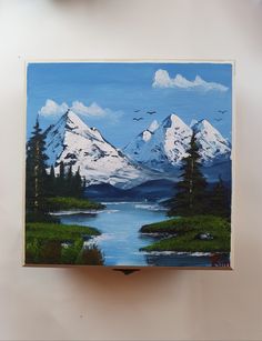 a painting of snow covered mountains is hanging on the wall