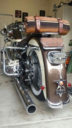 a motorcycle parked in a garage with its luggage strapped to the back seat and handlebars