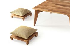 a wooden table with two small stools and a pillow on the bottom, both side by side