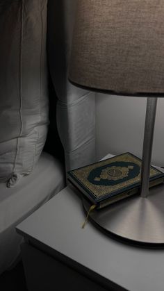 a book sitting on top of a table next to a lamp