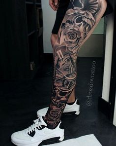 a man's leg with tattoos on it and white shoes in front of him