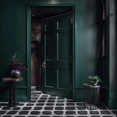 a room with green walls, black and white tile flooring and an open door