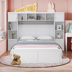 a teddy bear sitting on the floor in front of a bed with shelves above it