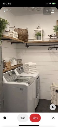 a washer and dryer sitting in a room next to some shelves with plants