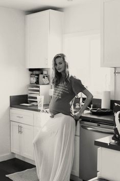 a woman is standing in the kitchen with her hands on her hips and looking at the camera