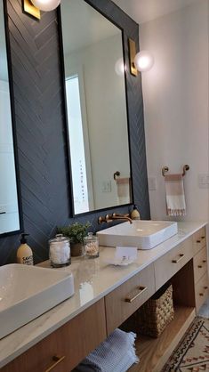 a bathroom with two sinks and a large mirror on the wall above it, along with other accessories