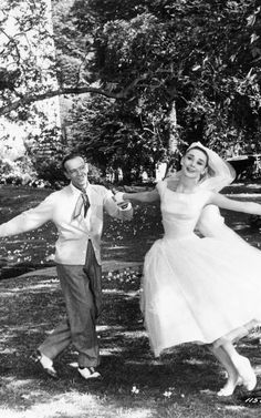 an old black and white photo of a man and woman dancing in the park together