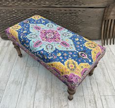 a bench that is sitting on the floor next to a piece of wood with a flower design on it