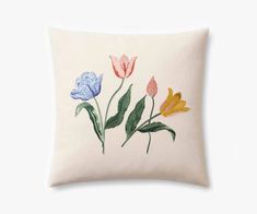 a white pillow with three different colored tulips on the front and one blue, yellow and pink flowers on the back