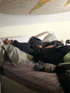 a man laying on top of a bed under a map