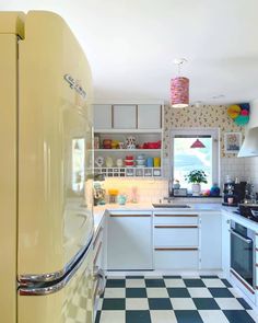 a yellow refrigerator freezer sitting inside of a kitchen next to a stove top oven