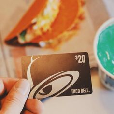 a person holding up a taco bell credit card