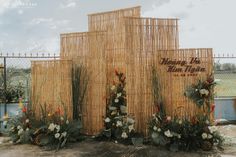 a bamboo fence with flowers and greenery on it