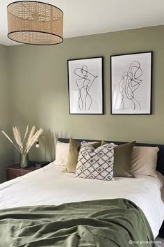 a bedroom with two pictures on the wall above the bed