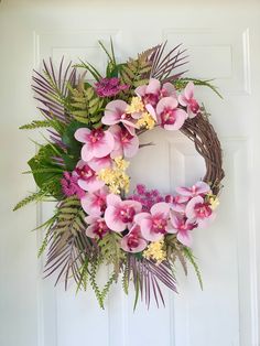 a wreath with pink flowers and green leaves