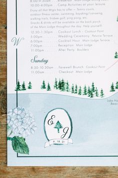 an image of a wedding program on a wooden table with snow and trees in the background