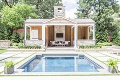 a pool house with an outdoor living area in the back ground and seating around it