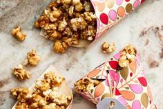 two paper cups filled with popcorn on top of a counter next to some other items