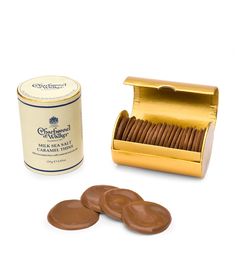 chocolate covered cookies in a gold box next to a can