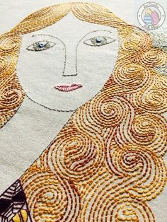 a close up of a piece of embroidery on a table cloth with an image of a woman's face