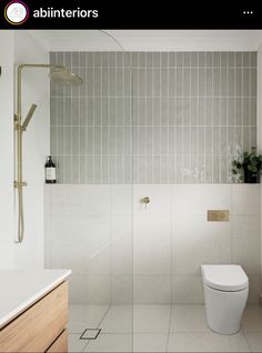 a bathroom with a toilet, sink and shower head in the wall next to it