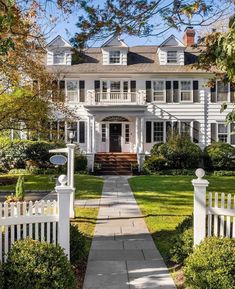 a large white house surrounded by trees and bushes