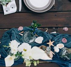 an arrangement of seashells and flowers on a table