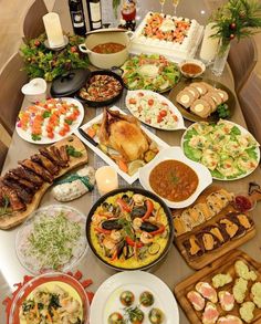 a table filled with lots of different types of food on plates and serving trays