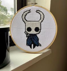 a cross - stitch pattern of a skull wearing a chef's hat and bow tie