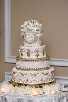 a three tiered wedding cake sitting on top of a table next to candles and flowers