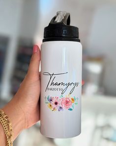 a person holding a white water bottle with the words pharmony on it and flowers