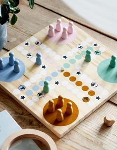 a wooden board game sitting on top of a table next to a potted plant