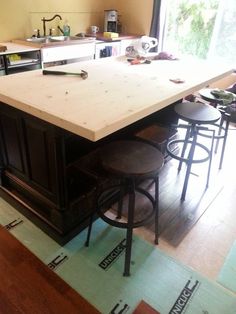 a kitchen island with stools in front of it