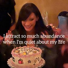 a woman sitting in front of a cake with the words i attract so much abundance when i'm quiet about my life