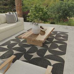 an outdoor living area with couches, table and coffee table in the middle of it