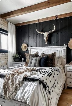 a white bed sitting in a bedroom next to a wooden wall with an animal head on it