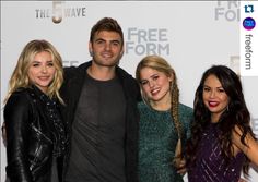 three women and one man are posing for a photo on the red carpet at an event