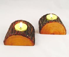 two small candles are sitting on logs