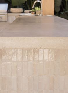 a kitchen counter top with a sink and stove in the background