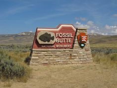 a sign for fossil butte national monument in the desert